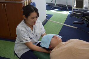 日野市 高幡不動駅 多摩鍼灸整骨院 高幡不動院で首の施術をする女性施術者
