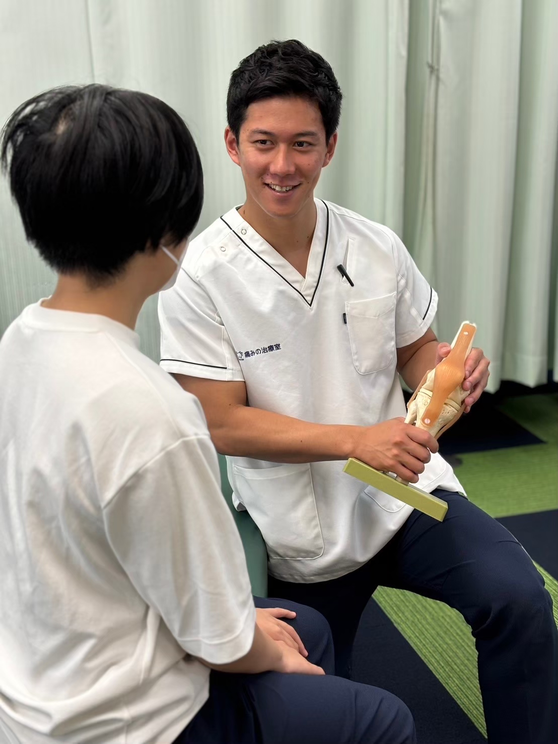 高幡不動院で交通事故後の腰痛を相談する様子