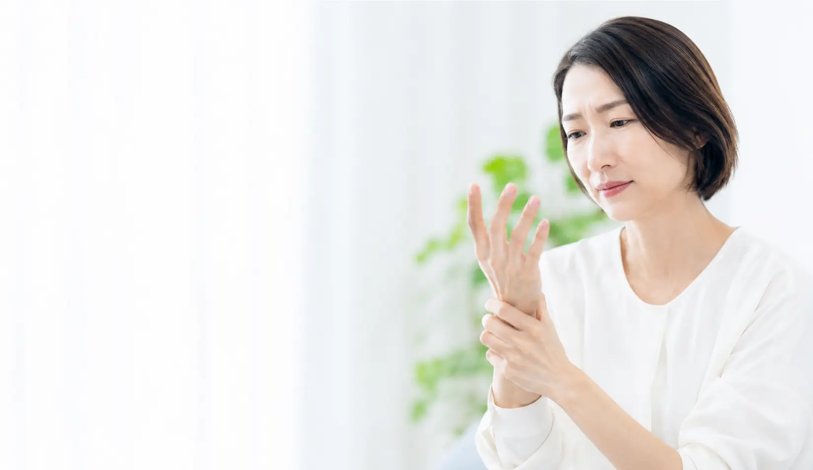手や指のしびれを感じ、手の状態を確認する女性