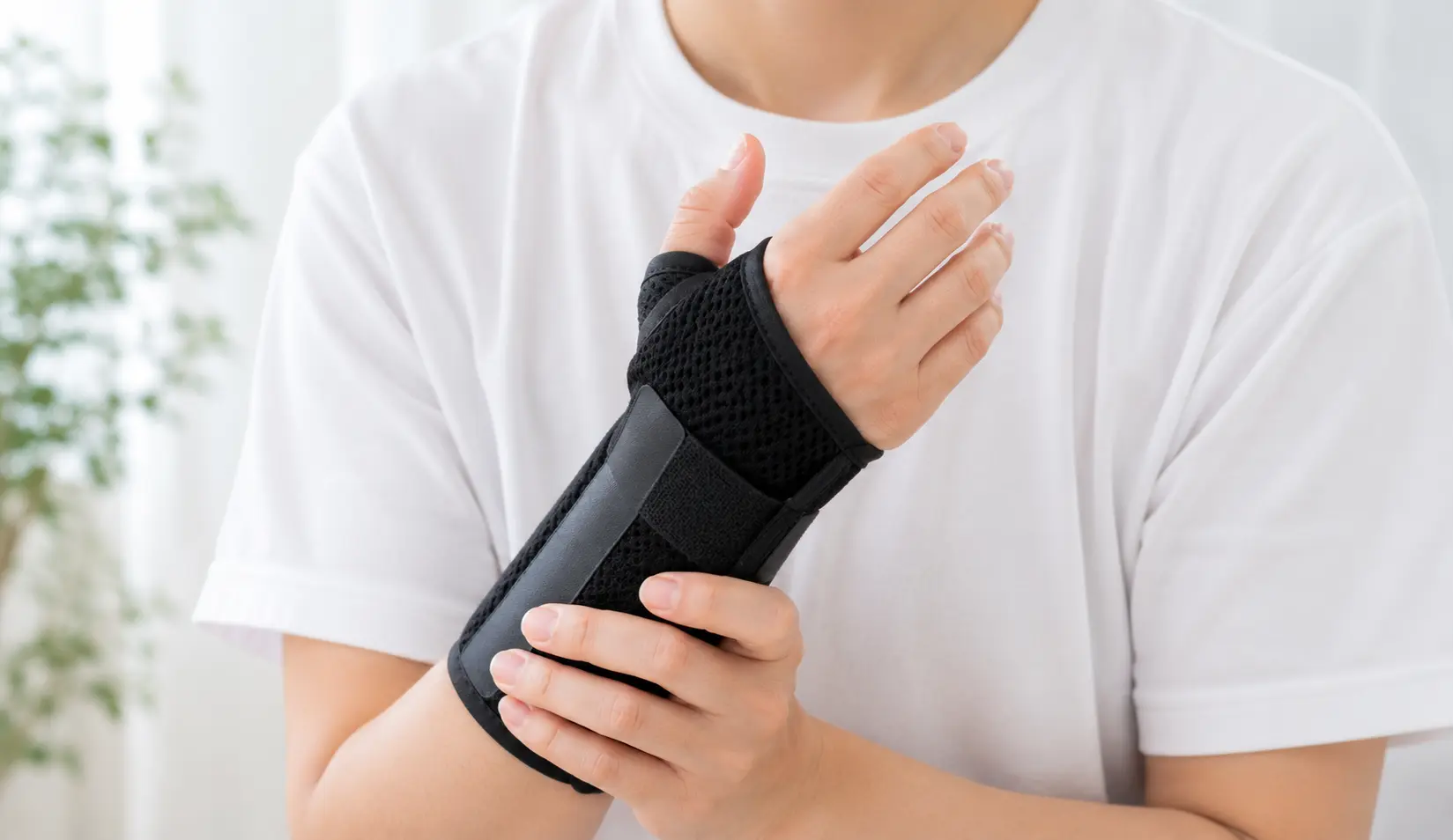 ショーファー骨折により手首の親指側をサポーターで固定している人物のイメージ