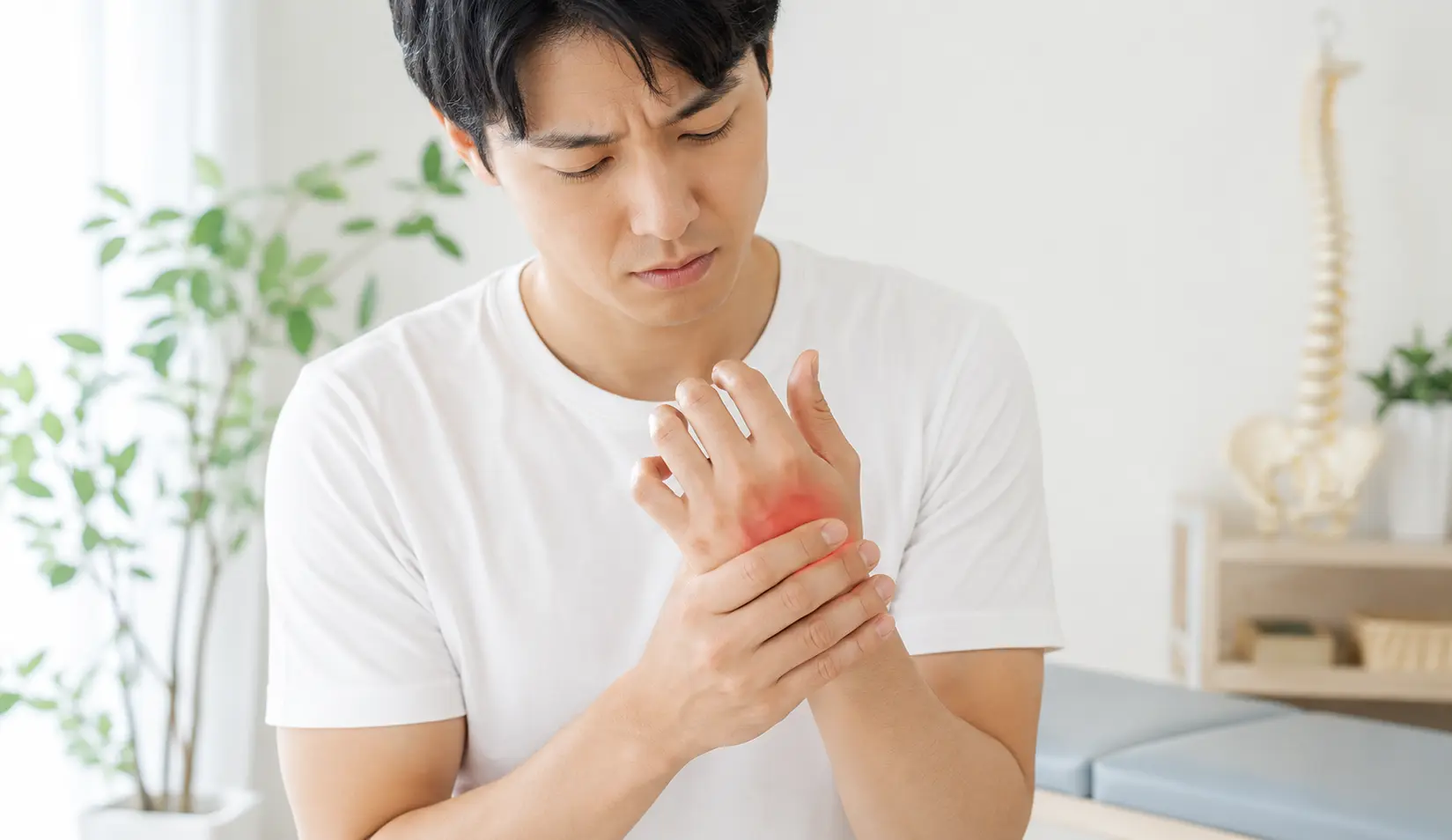 ボクサー骨折により、小指側の手の甲に痛みや腫れを感じている男性のイメージ