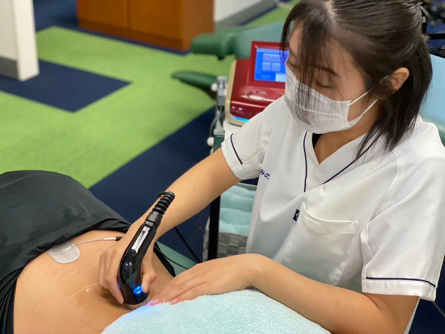 女性施術者が腰の不調に対してコンビネーション施術を行っている様子。八王子市・日野市で腰痛やぎっくり腰の施術相談を行う多摩鍼灸整骨院グループの施術イメージ